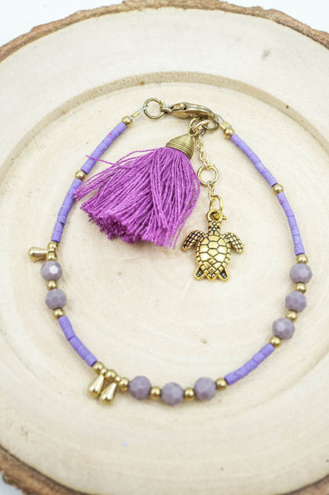 Bracelet perles de verre violettes avec pompon et tortue
