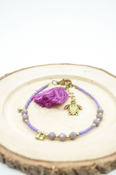 Bracelet perles de verre violettes avec pompon et tortue