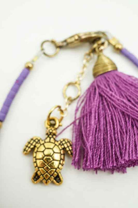 Bracelet perles de verre violettes avec pompon et tortue